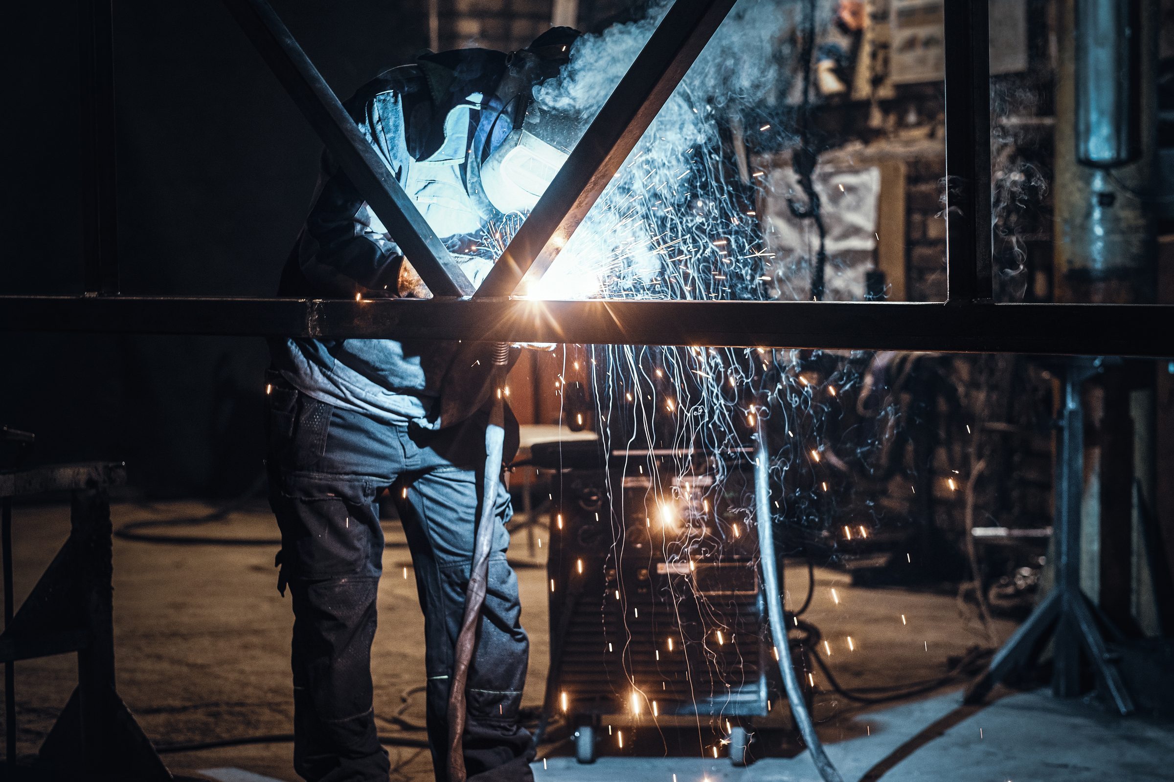 Welder fabricating a steel frame